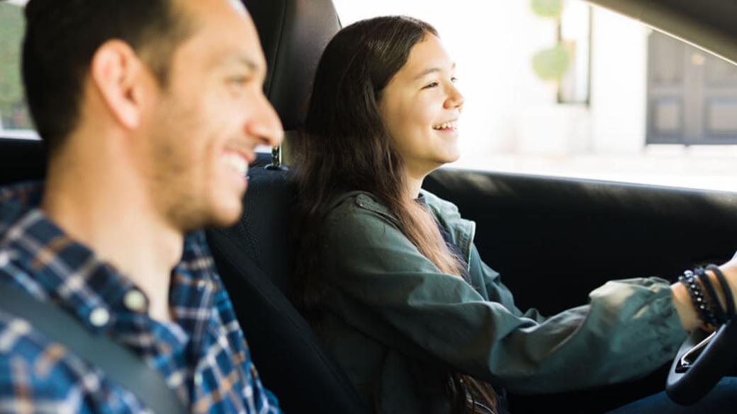 Une personne apprend à un proche à conduire.